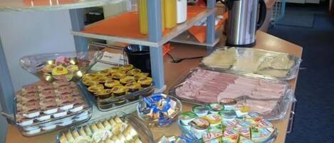A buffet table with various food items and kitchen appliances.