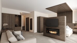 A modern living room with a flat-screen TV, a fireplace, a sofa, and a coffee table. - Bonfanti Design Hotel (Chienes)