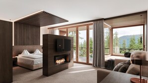 A modern living room with a fireplace, a sofa, a TV, and a balcony with a scenic view. - Bonfanti Design Hotel (Chienes)