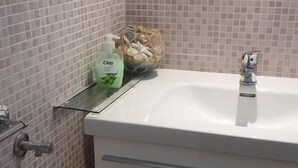 A bathroom with a white sink, tiled walls, and a mirror. - Hotel Massena (Genoa)