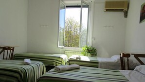 A room with two beds, a window, and a plant. - Hotel Massena (Genoa)