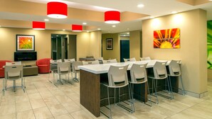 Un comedor moderno con una isla central, varias mesas y sillas.