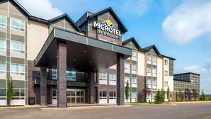 Un hotel Microtel by Wyndham con diseño moderno, que cuenta con una entrada cubierta y varios pisos.
