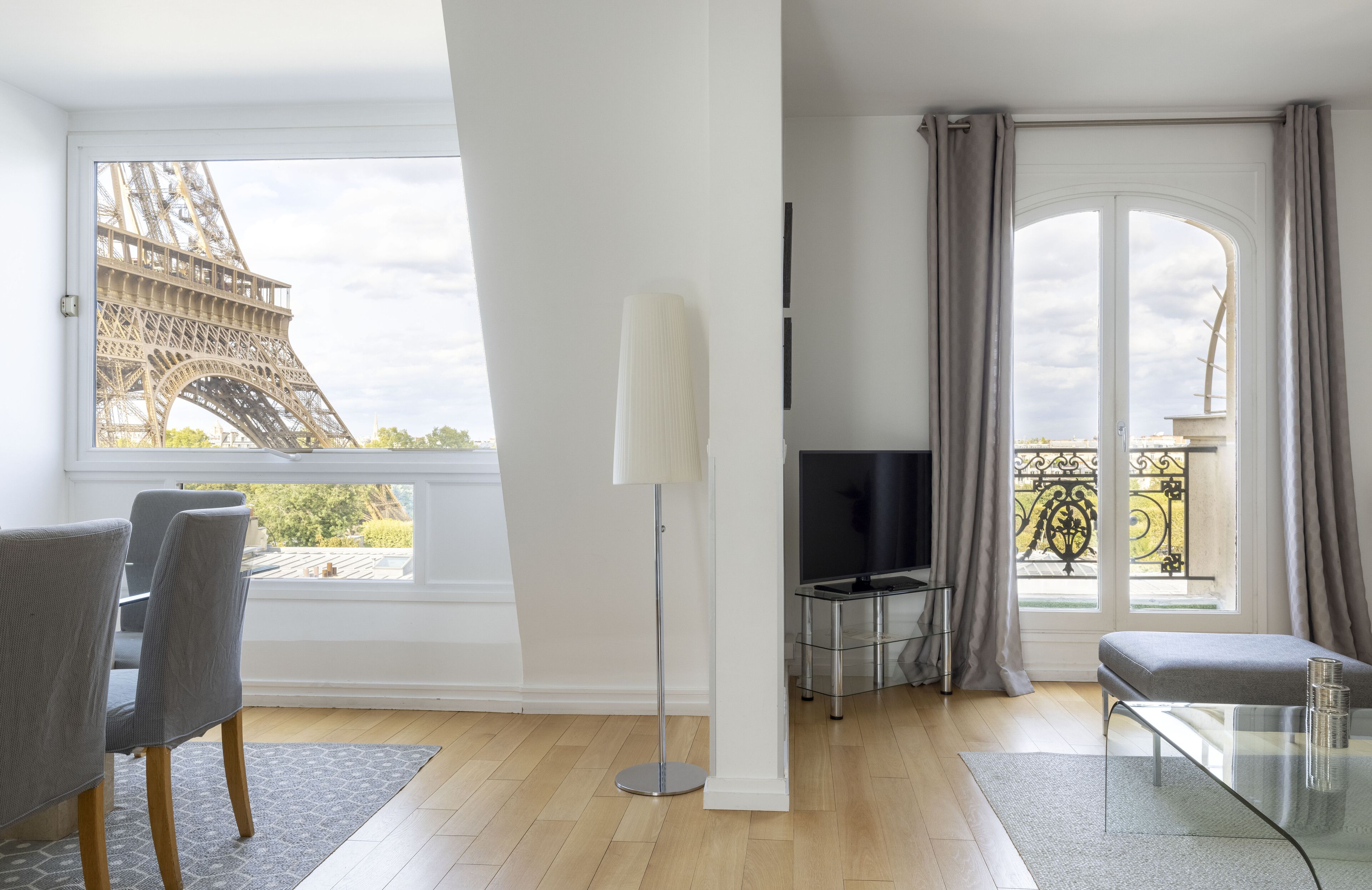Un salon moderne doté d’une grande fenêtre donnant sur la Tour Eiffel.