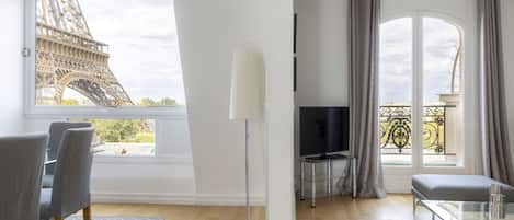Un salon moderne doté d’une grande fenêtre donnant sur la Tour Eiffel.