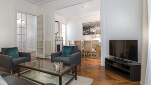 A spacious living room with a large flat-screen TV, two sofas, and a coffee table. - Résidence Charles Floquet (Paris)