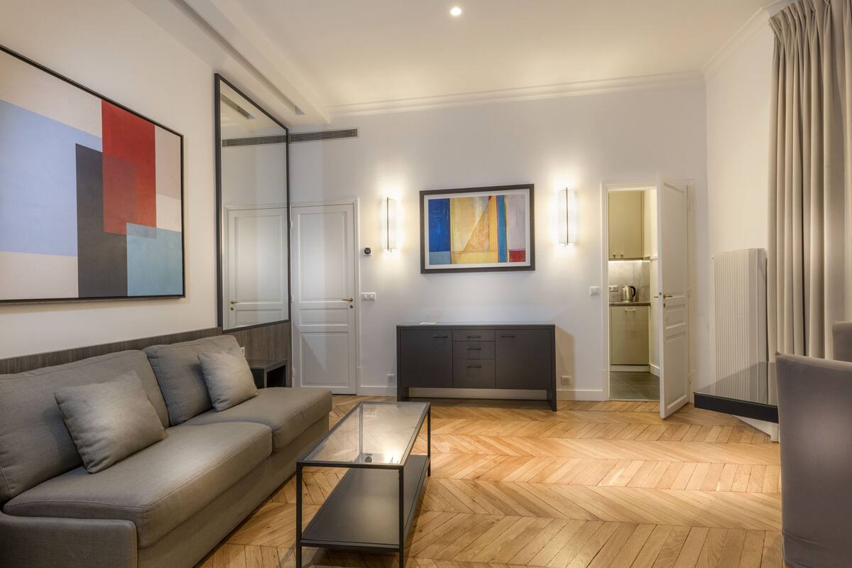 A modern living room with a sofa, coffee table, and artwork on the wall.