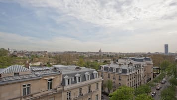 A cityscape with historic buildings, a clear sky, and a distant modern skyscraper.