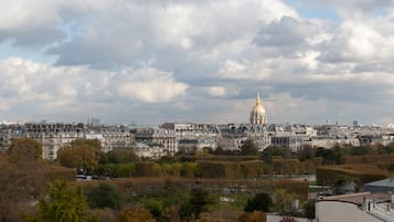 A cityscape with a prominent golden-domed building in the distance, surrounded by dense urban buildings and trees.