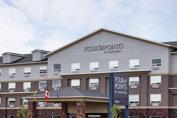 Un hotel de varios pisos con fachada gris y un letrero que dice "FOUR POINTS BY SHERATON".
