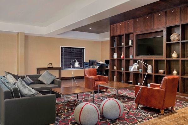 A modern living room with leather sofas, a coffee table, and a patterned carpet. - Four Points By Sheraton Regina (Regina)
