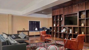 Una sala de estar moderna con sofá, sillones, una mesita de centro y mueble para televisión.
