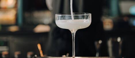 Un barman sirve una bebida en un vaso.