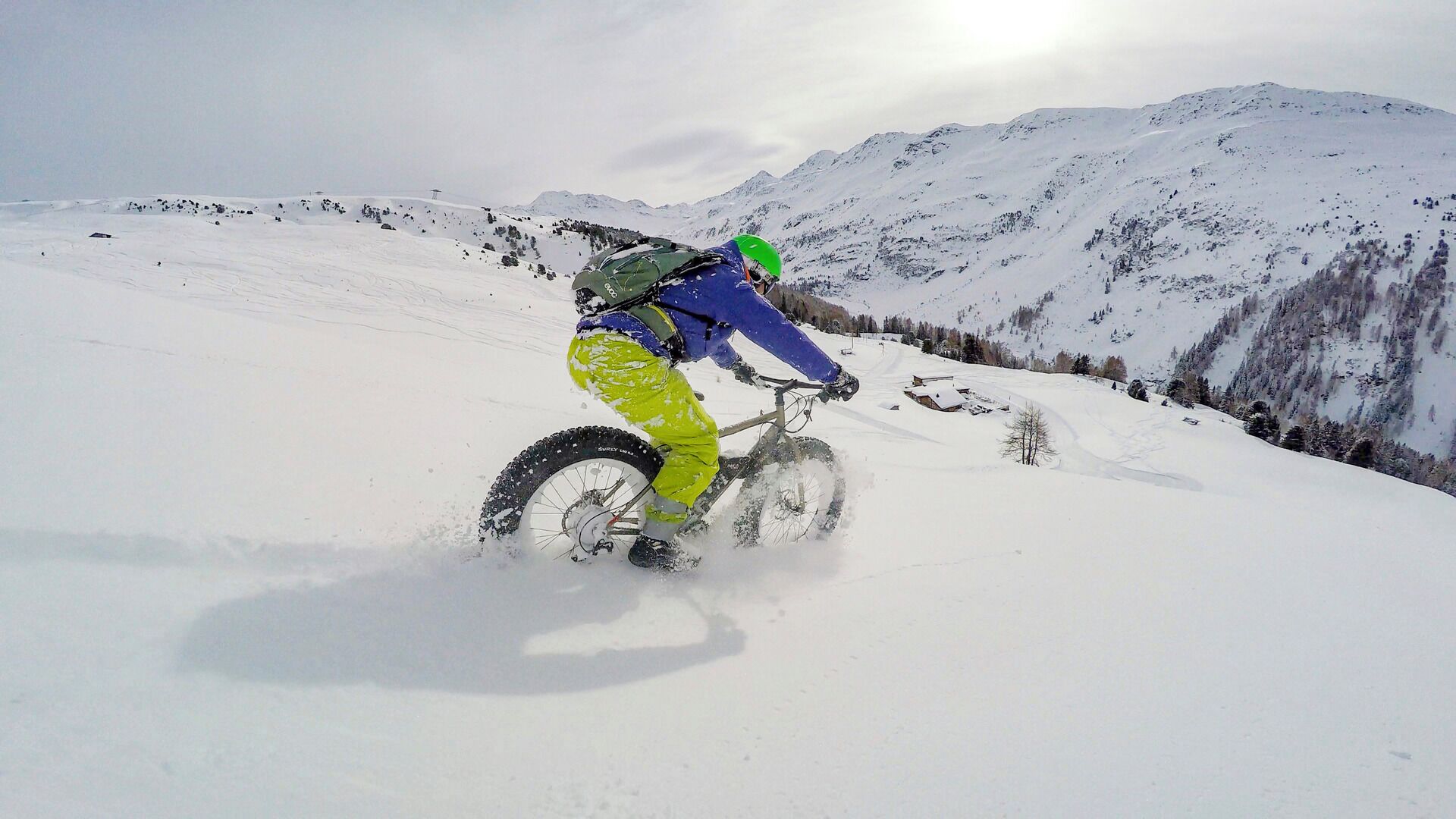 A person riding a bicycle on a snowy mountain.