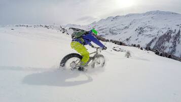 A person riding a bicycle on a snowy mountain.