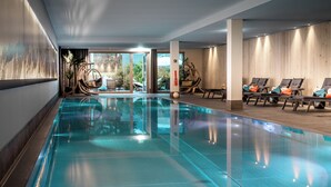 A swimming pool with lounge chairs and a view of the outdoors. - AMERON Davos Swiss Mountain Resort (Davos)