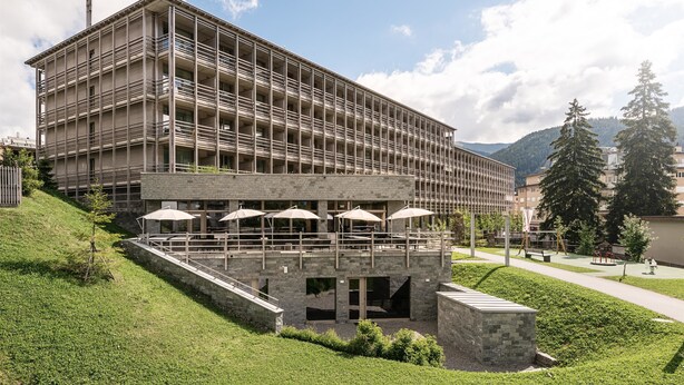 A multi-story hotel with outdoor seating and a stone facade. - AMERON Davos Swiss Mountain Resort (Davos)