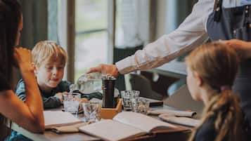 A table with a coffee maker, glasses, and books, suggesting a casual dining or meeting space.