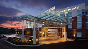 Entrada de un hotel Hyatt Place con un paseo techado, puertas de vidrio y fachada de ladrillo.