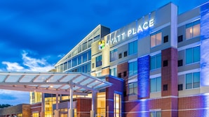 A modern hotel building with a glass facade and a sign reading "Hyatt Place".