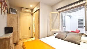 A bedroom with a bed, bedside table, and a window with a view. - Ten Hostel (Ibiza Town)