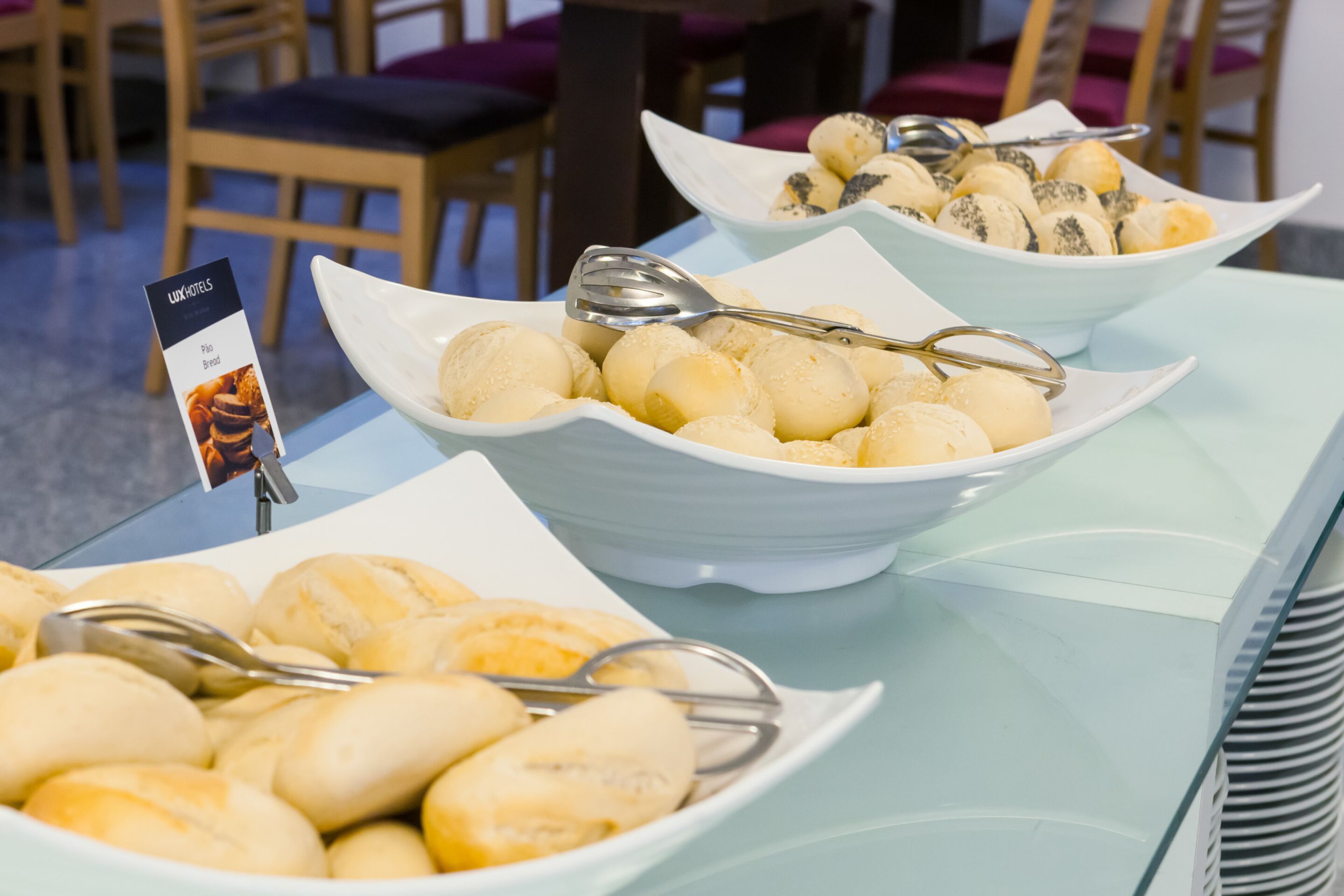 Una mesa de buffet con varios panecillos y bollería.