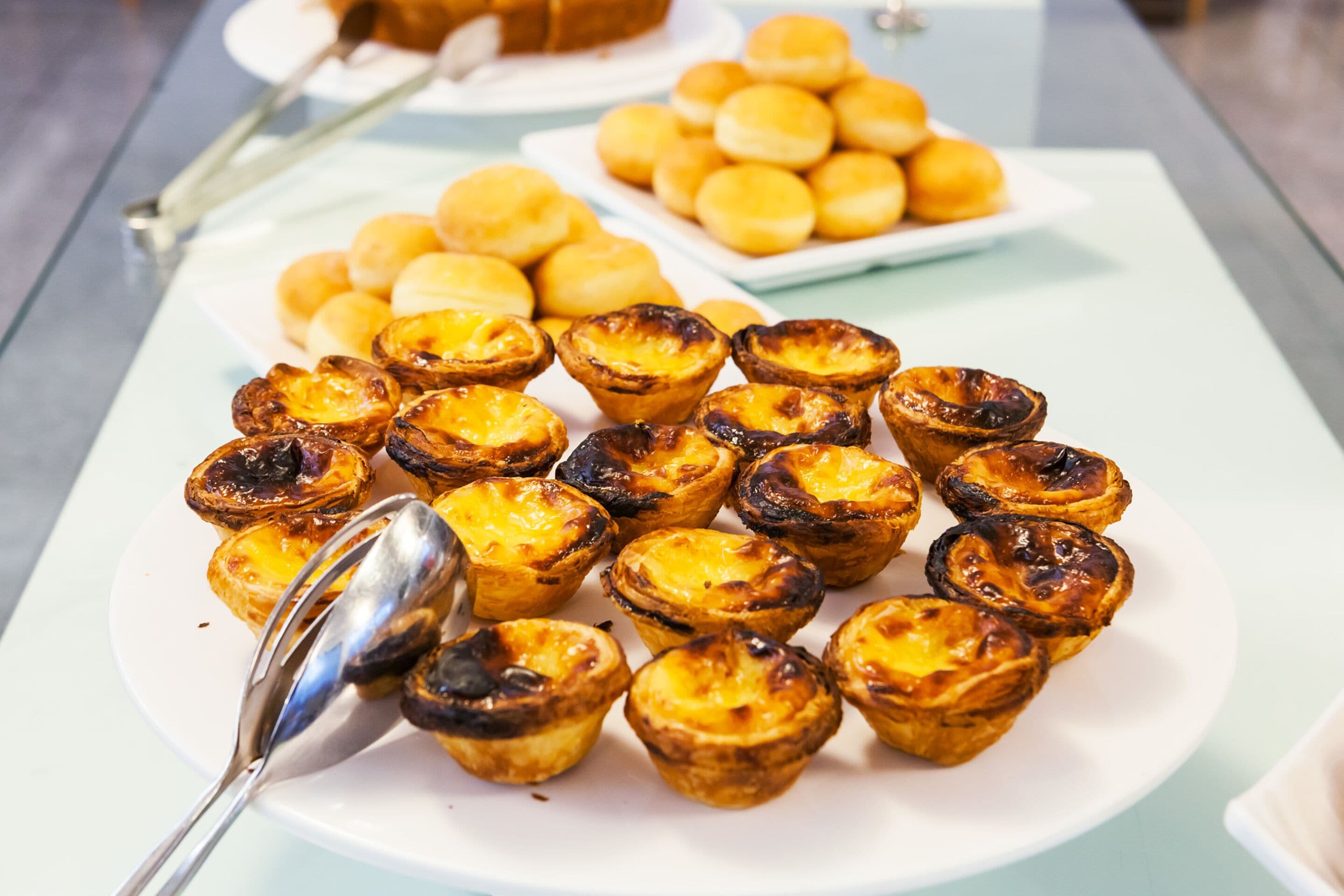 Ein Teller mit portugiesischen Eiertörtchen und Custard-Brötchen.