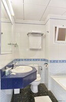 Een badkamer met een wit wastafel, een blauw aanrecht, toilet en een bad.