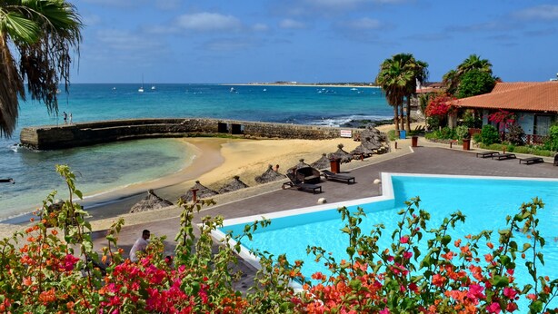 A beachfront hotel with a swimming pool, beach access, and ocean views.