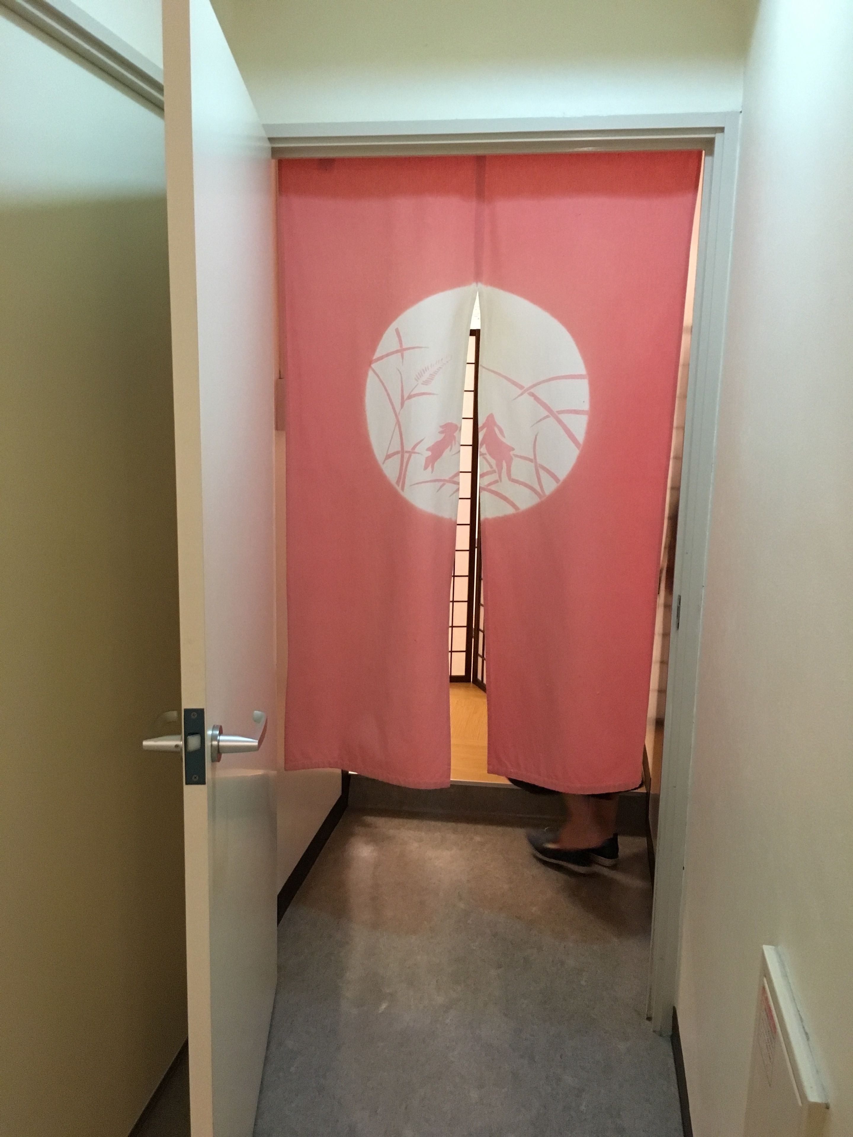 Un couloir étroit doté d’une porte coulissante ornée d’un motif circulaire.
