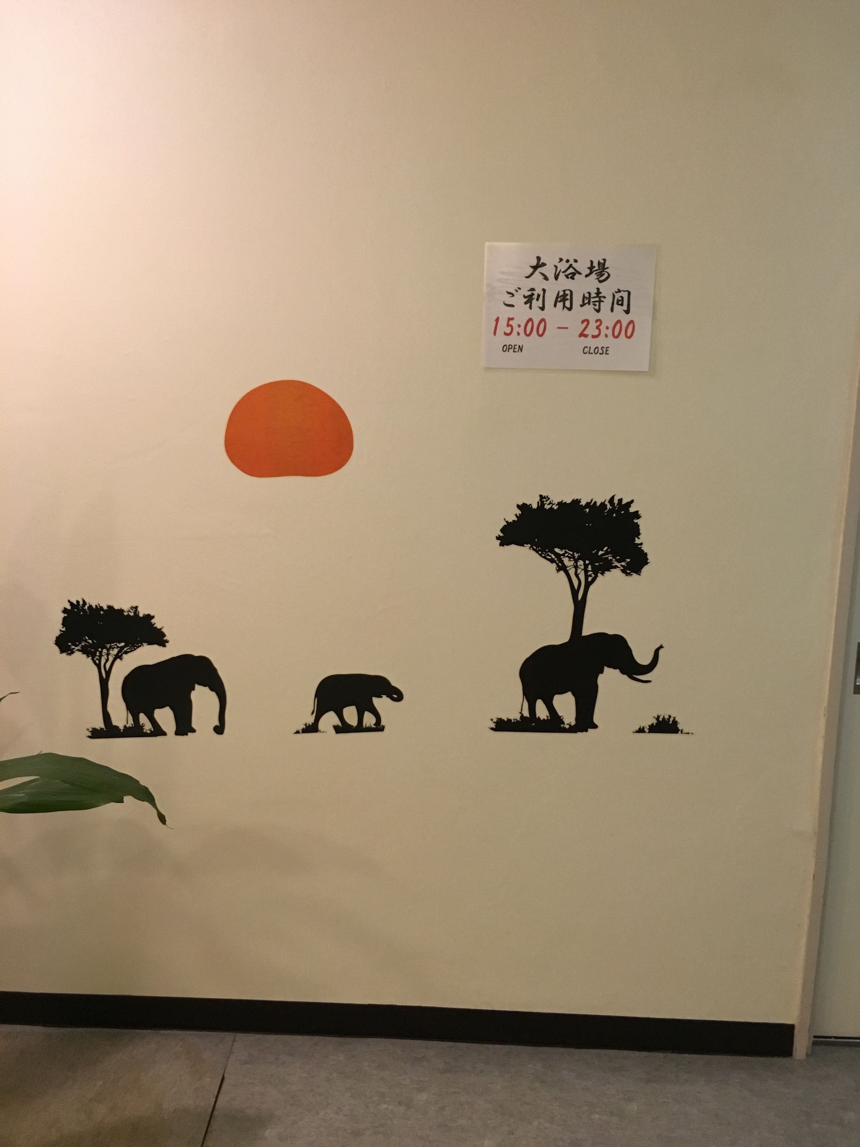 A wall with a sign indicating the business hours of 15:00 to 23:00.