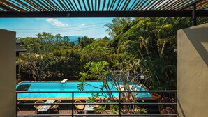 A pool with a view of lush greenery and mountains in the background.