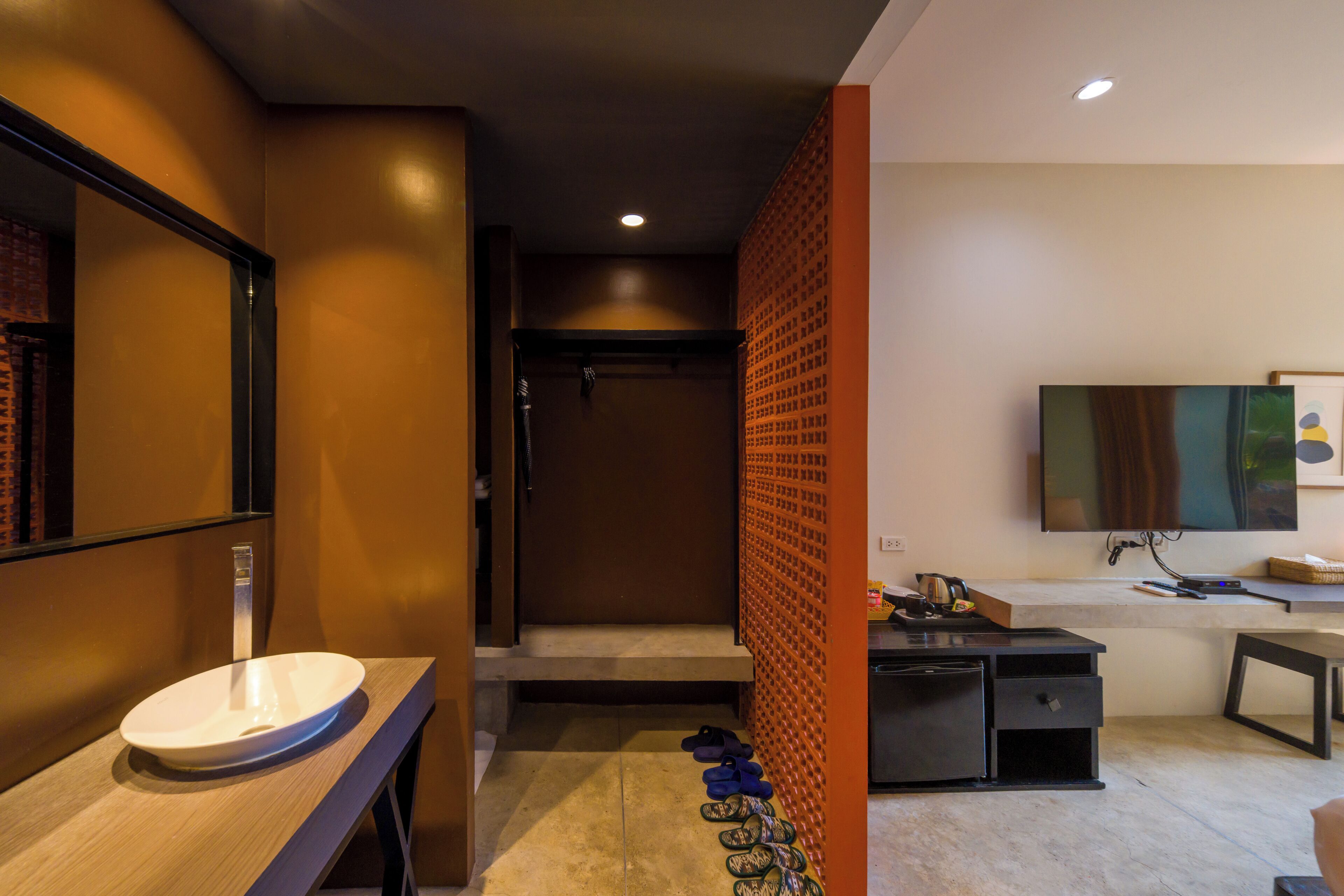 A modern bathroom with a sink, mirror, and a shower area.