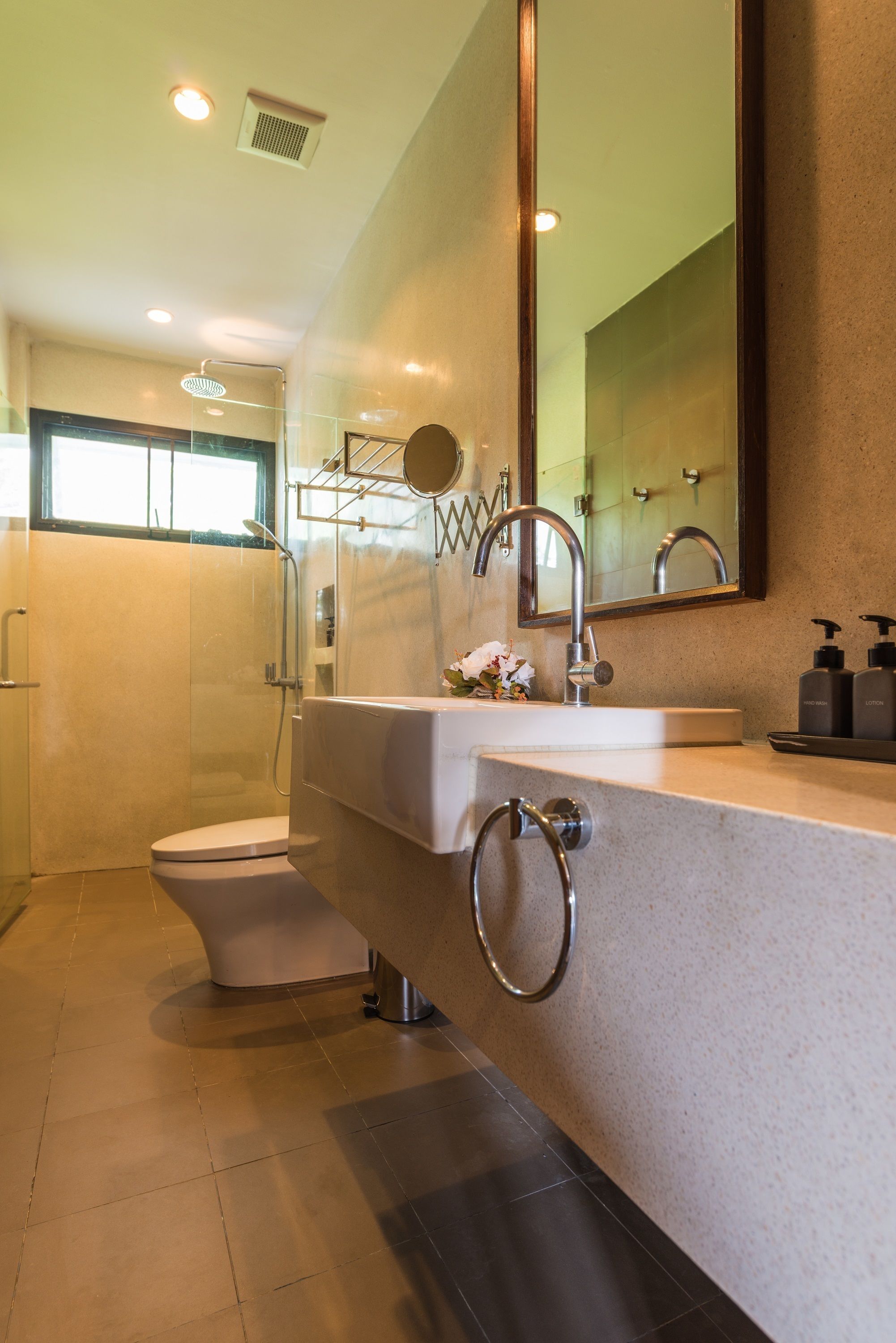 Een moderne badkamer met douche, toilet en wastafel.