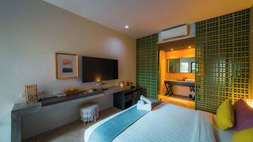 A modern hotel room with a bed, a desk, a television, and a bathroom.