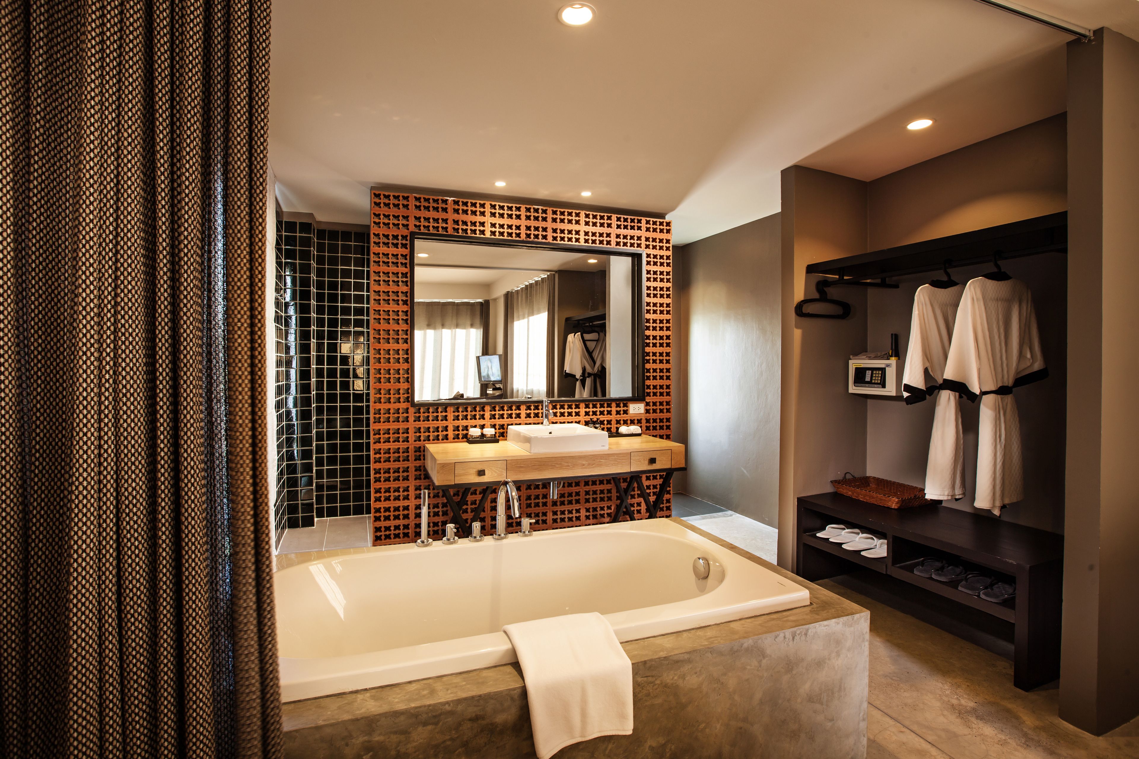 A modern bathroom with a large bathtub, two sinks, a mirror, and a towel rack.