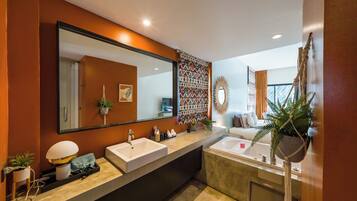 A modern bathroom with two sinks, a bathtub, a large mirror, and a decorative wall panel.