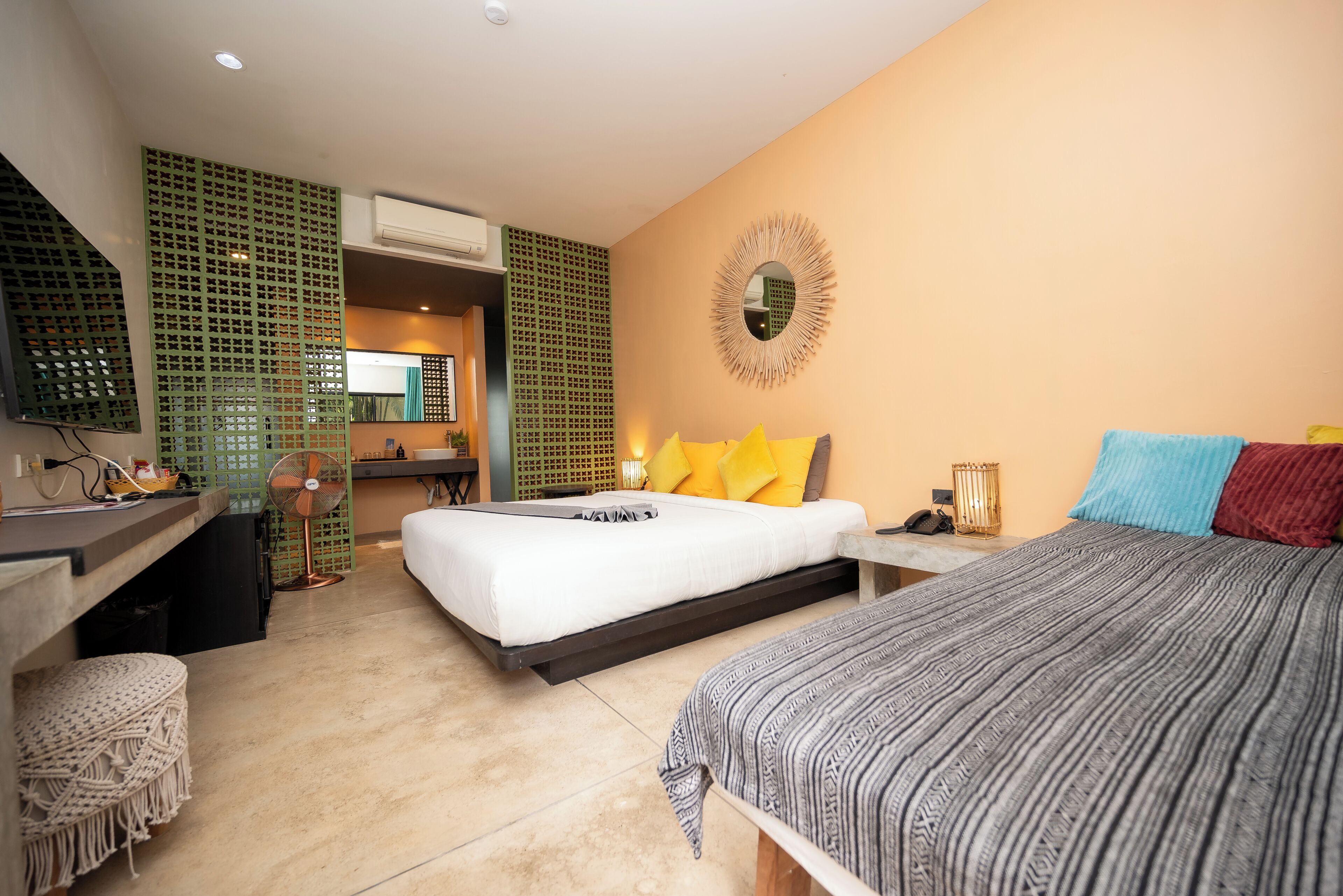 A modern hotel room with a bed, desk, and a small sitting area.