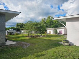 Un camping con varias cabañas blancas, un área de césped y árboles.