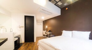 Ein modernes Hotelzimmer mit Bett, Schreibtisch und Bad.