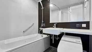 A modern bathroom with a bathtub, a toilet, a sink, and a shower.