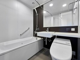 A modern bathroom with a bathtub, a toilet, a sink, and a shower.