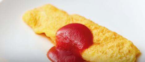 A plate with a folded omelette and a dollop of red sauce.