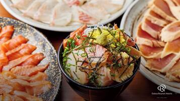 A bowl of sashimi with green onions and seaweed garnish.