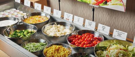 A salad bar with various vegetables and salads.