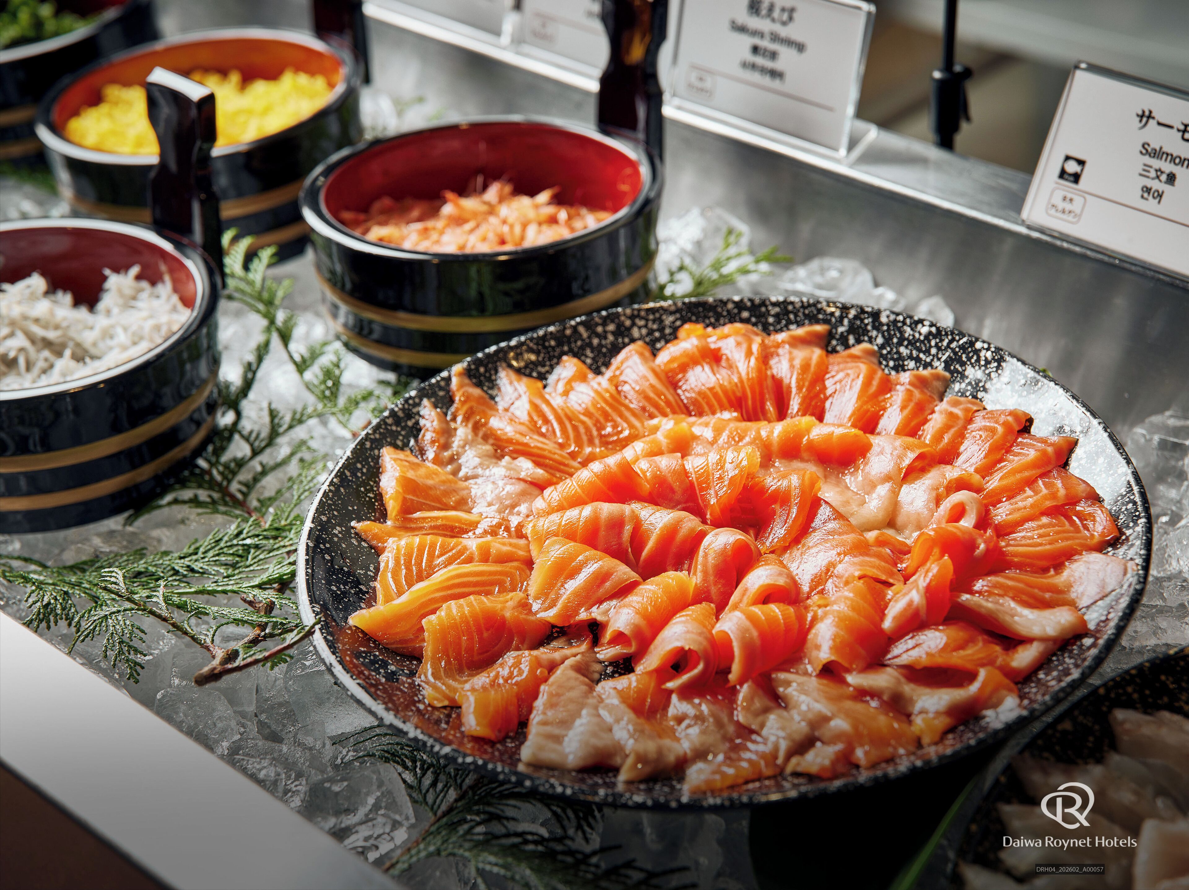 A buffet with various dishes including salmon arranged on a plate.