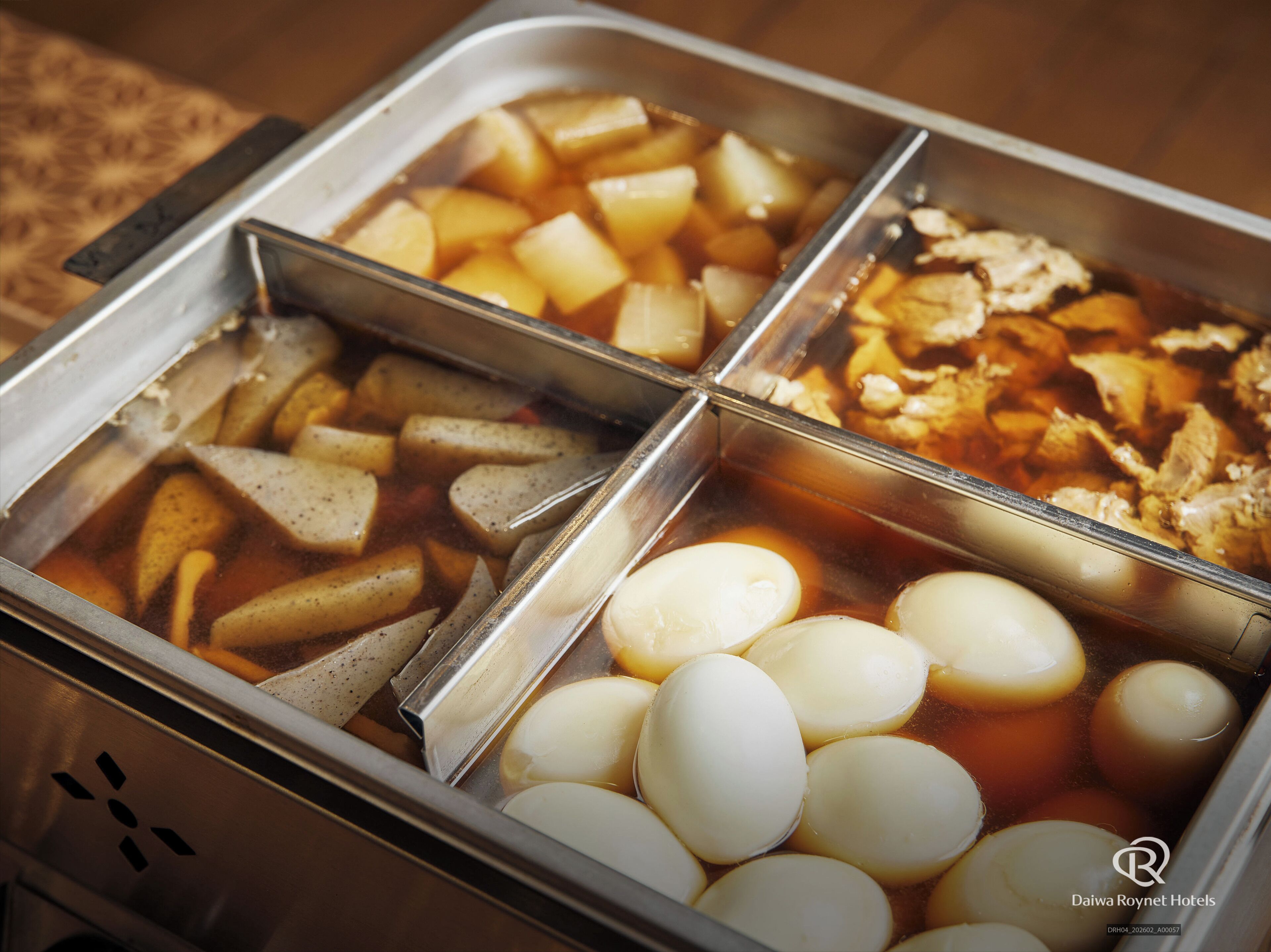 Un bufé con diversas opciones de comida, incluyendo patatas, carne y huevos cocidos.