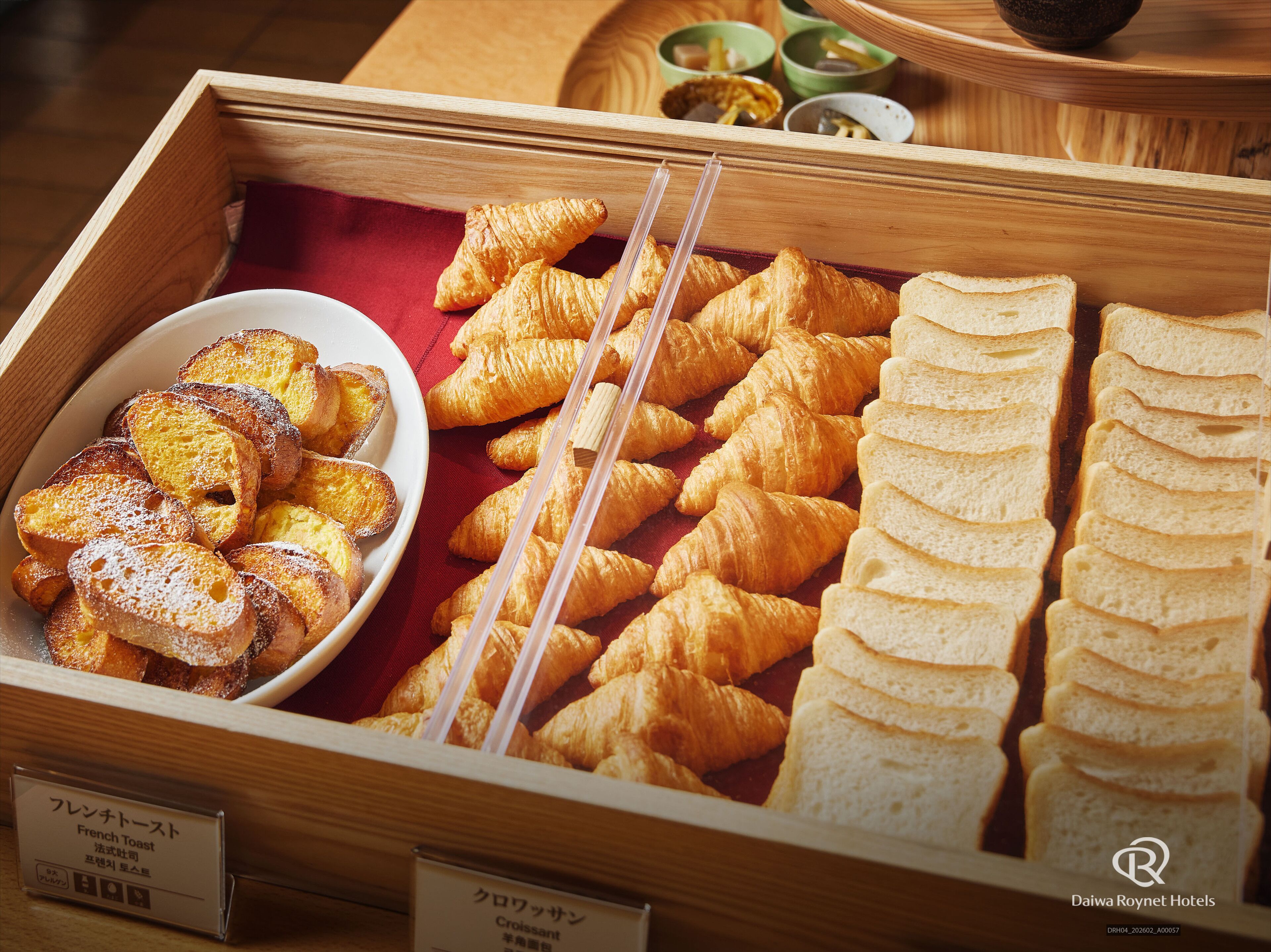 A breakfast buffet with croissants, French toast, and bread slices.