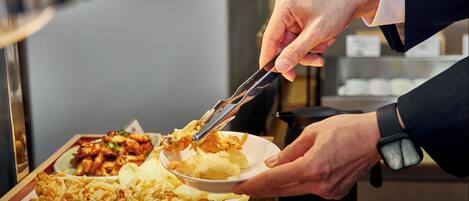 A person serving food from a tray to another person.