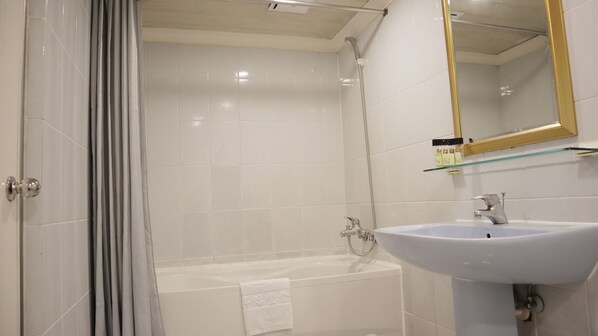 A bathroom with a bathtub, a sink, and a shower.